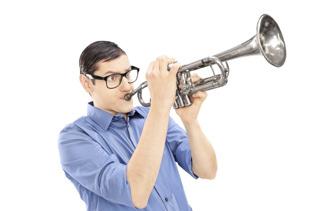 Young male trumpeter playing the trumpet isolated on white background